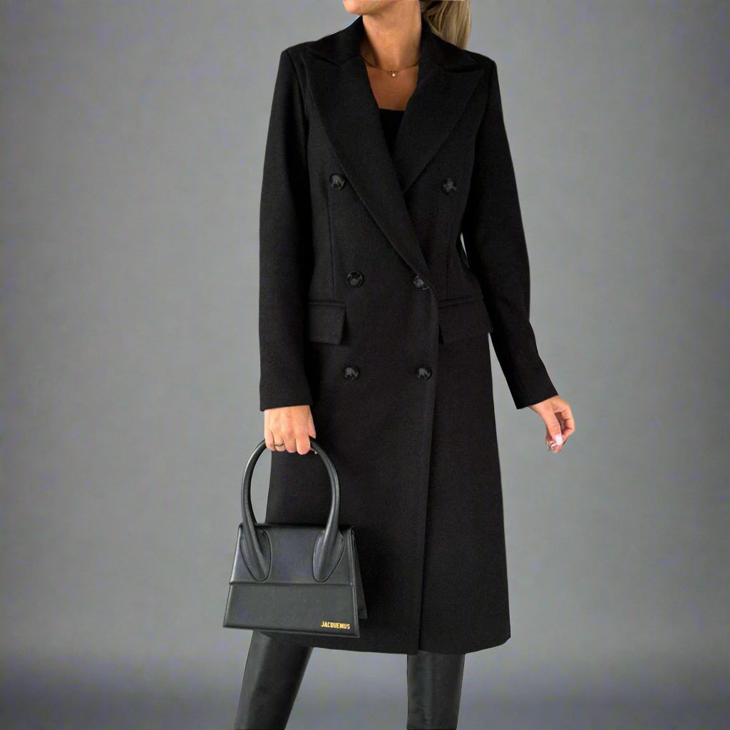 Zwarte winterjas voor dames, dubbele rij knopen, elegante lange mantel, gecombineerd met zwarte handtas en laarzen, modieuze winterkleding.