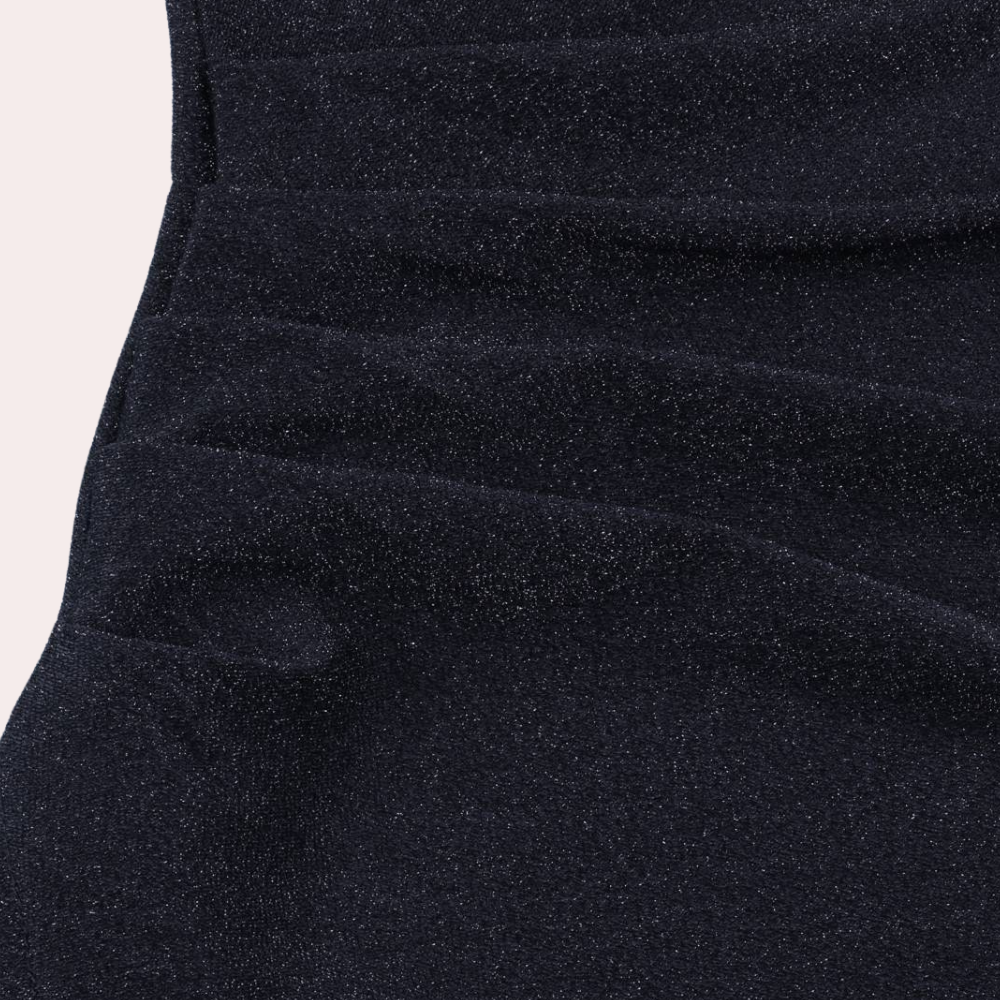 Zwarte glitterstof close-up, glanzend textiel met subtiele plooien, ideaal voor avondkleding en feestjurken. Luxe en elegantie in modeontwerp.
