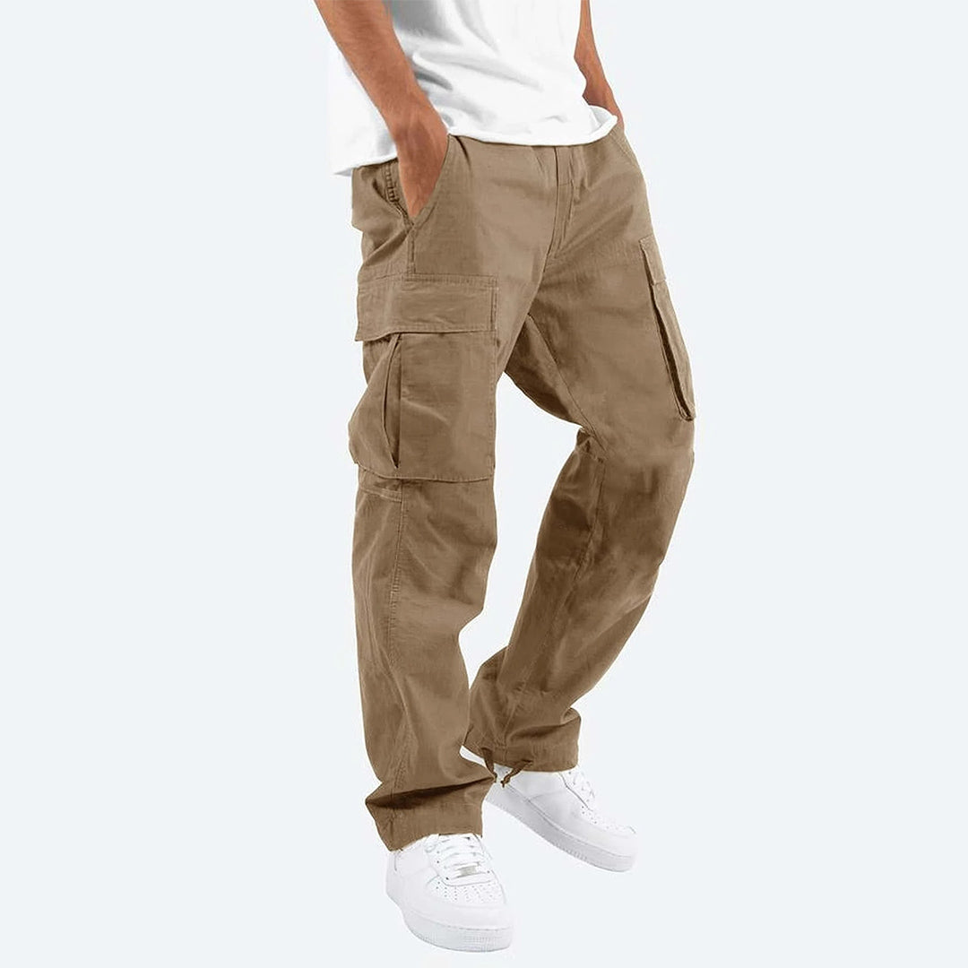 Beige cargobroek voor heren, Ryker model, met meerdere zakken, casual stijl, gedragen met witte sneakers en een wit T-shirt.