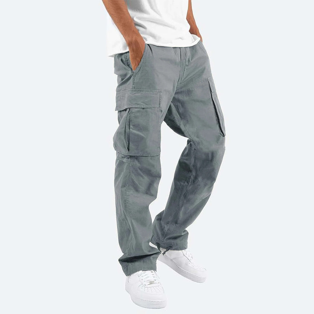 Grijze cargobroek voor heren, Ryker model, met meerdere zakken, casual streetwear stijl, gecombineerd met witte sneakers en een wit T-shirt.