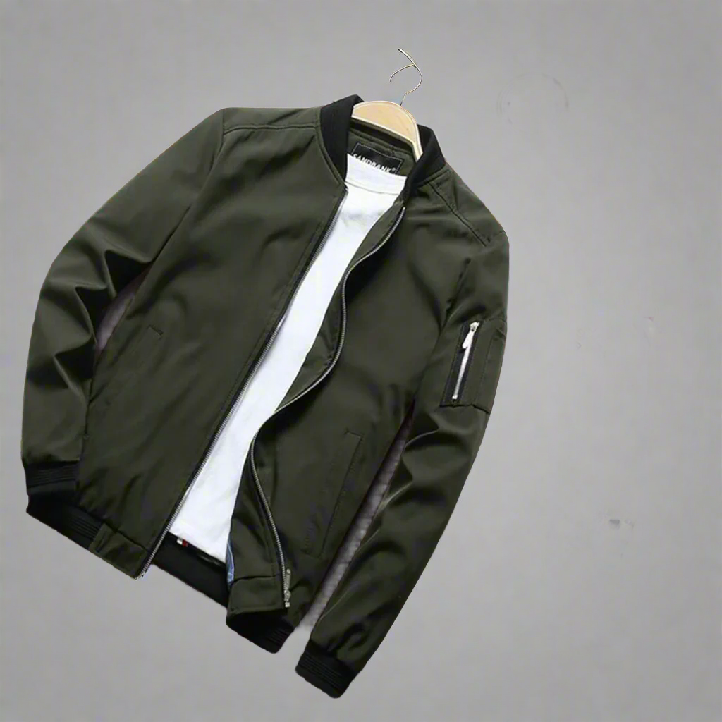 Stijlvolle groene zomerjas voor heren op houten vloer, met witte T-shirt, zwarte zonnebril, horloge en wekker. Perfecte casual herenkleding.